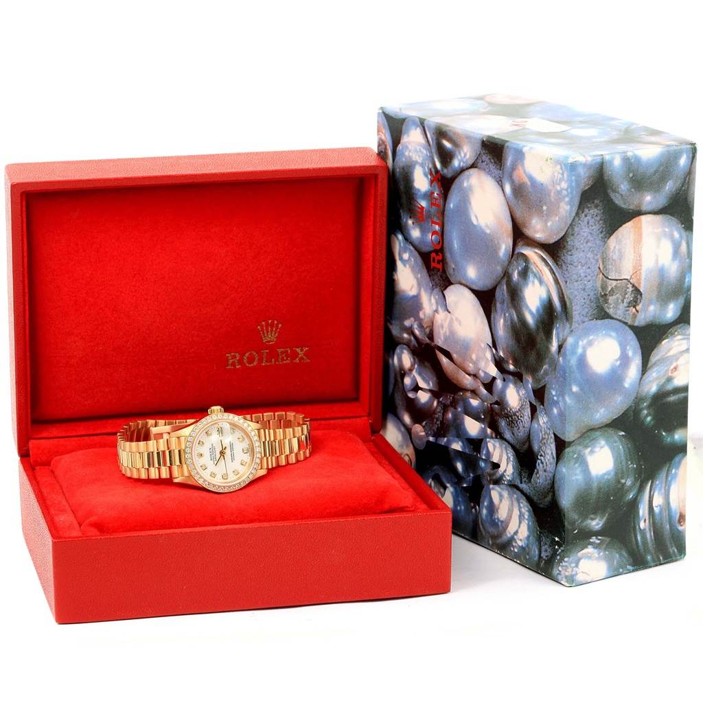 This image shows a Rolex President 69138 Women
s Yellow Gold White Dial 69138 Women
s Yellow Gold White Dial watch inside an open red box, with the outer box beside it.