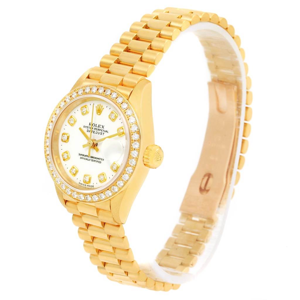 The Rolex President 69138 Women
s Yellow Gold White Dial 69138 Women
s Yellow Gold White Dial model watch is shown at an angle highlighting its gold band, diamond-encrusted bezel, crown, and face.