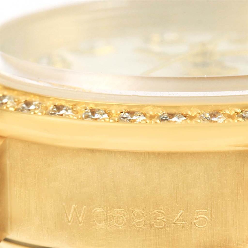 This close-up shot of the Rolex President 69138 Women
s Yellow Gold White Dial 69138 Women
s Yellow Gold White Dial model shows the bejeweled bezel, crystal, and part of the gold case with an engraved serial number.