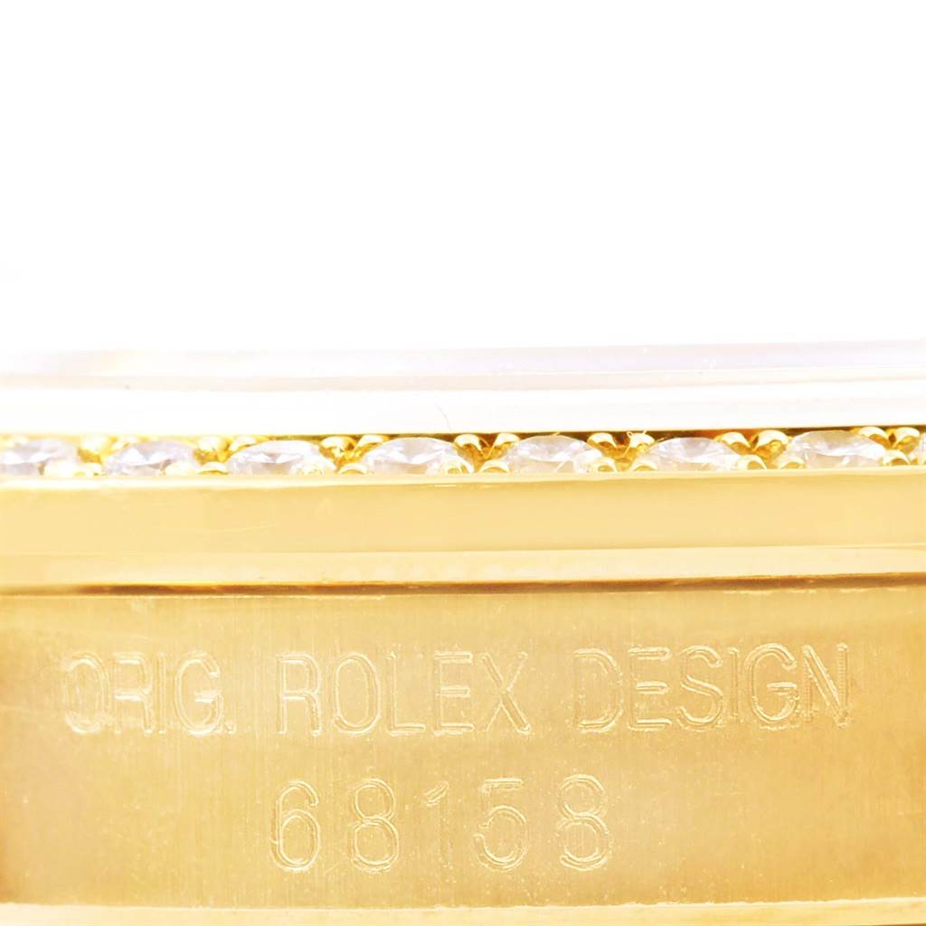 The image shows a close-up angle of the side of the Rolex President 68158 Women's Yellow Gold Champagne Dial 68158 Women's Yellow Gold Champagne Dial model, revealing its design engraving and part of its bejeweled bezel.