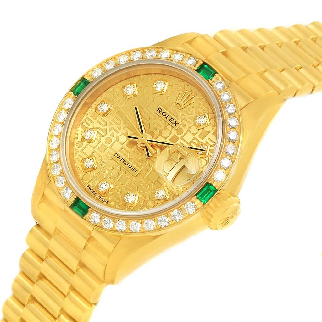 The image shows a Rolex President 69078 Women's Yellow Gold Champagne Dial 69078 Women's Yellow Gold Champagne Dial model watch with a gold dial, diamond markers, emerald accents, and a gold bracelet.