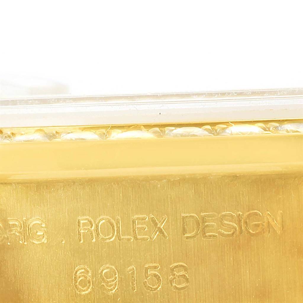 The image shows a close-up of the engraved model number and part of the bezel of a Rolex President 69158 Women's Yellow Gold Champagne Dial 69158 Women's Yellow Gold Champagne Dial watch.