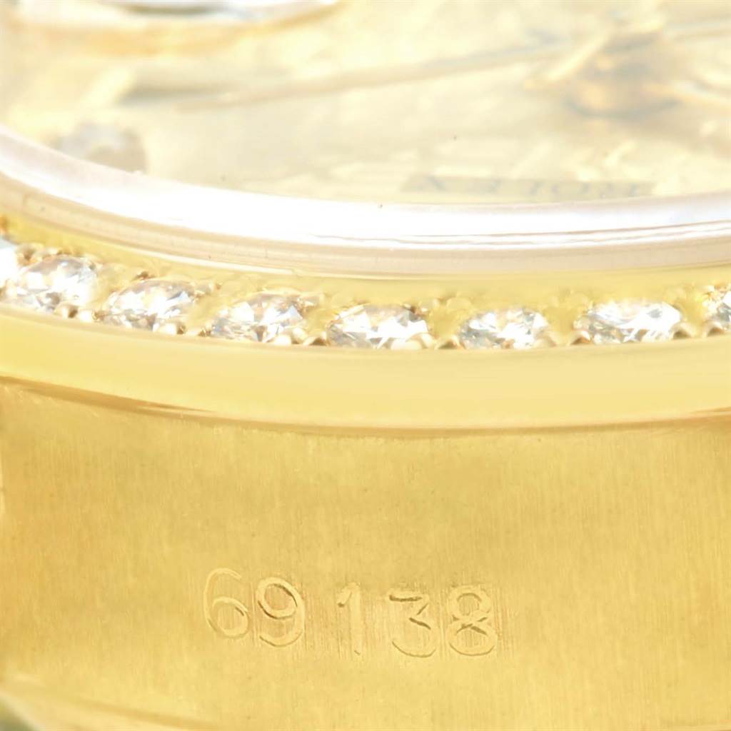 This image shows a close-up of the serial number and diamond-encrusted bezel of a Rolex President 69138 Women's Yellow Gold Champagne Dial 69138 Women's Yellow Gold Champagne Dial model.