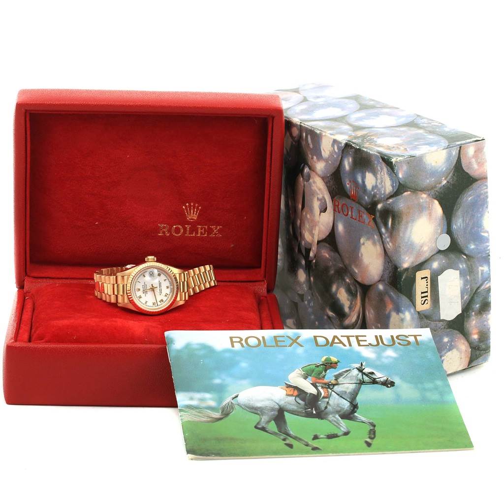 The image shows a Rolex President 69178 Women's Yellow Gold White Dial 69178 Women's Yellow Gold White Dial watch front angle, in its red box with a booklet and an outer box beside it.