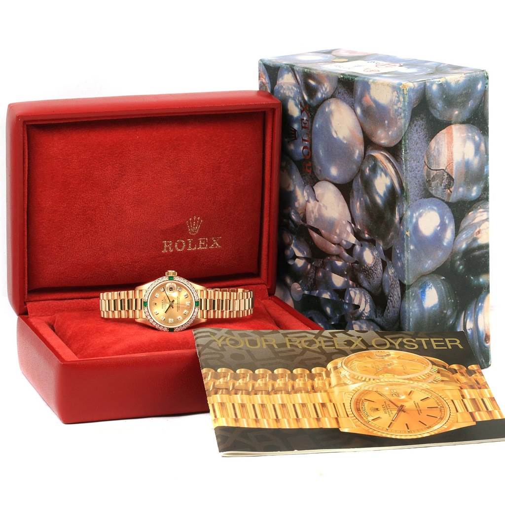 The Rolex President 69078 Women's Yellow Gold Champagne Dial 69078 Women's Yellow Gold Champagne Dial model is shown at a front angle in a red box, alongside its outer packaging and a booklet.