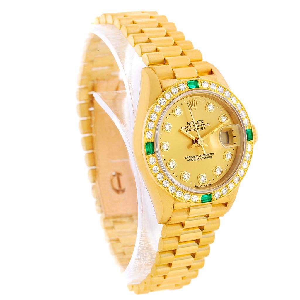The image shows a side angle of a Rolex President 69078 Women's Yellow Gold Champagne Dial 69078 Women's Yellow Gold Champagne Dial model watch, displaying the watch face, band, and bezel with diamonds and green accents.