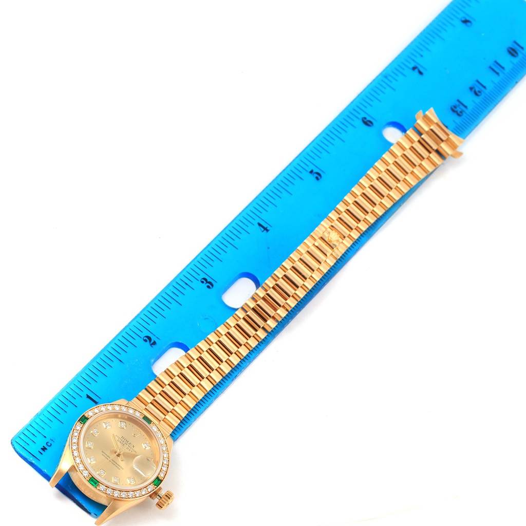The image shows a Rolex President 69078 Women's Yellow Gold Champagne Dial 69078 Women's Yellow Gold Champagne Dial model watch, placed next to a blue ruler, displaying the face and bracelet band.