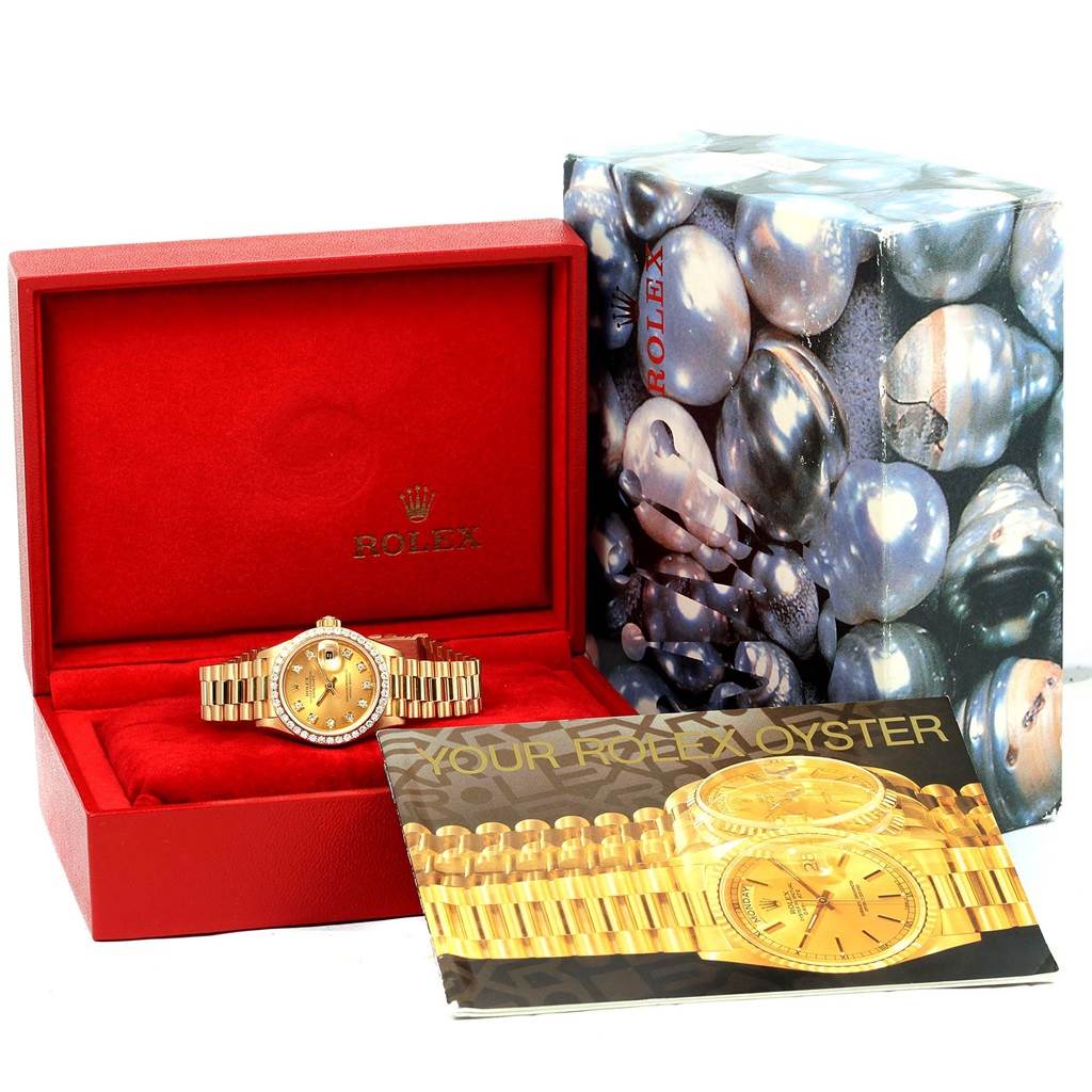 The image displays a Rolex President 69138 Women's Yellow Gold Champagne Dial 69138 Women's Yellow Gold Champagne Dial model watch in its box, shot from a front angle, along with its documentation.