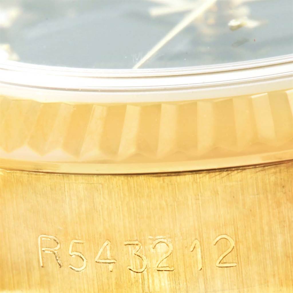 This image shows a close-up of the side of a Rolex President 69178 Women's Yellow Gold Black Dial 69178 Women's Yellow Gold Black Dial model watch, focusing on the fluted bezel and serial number.