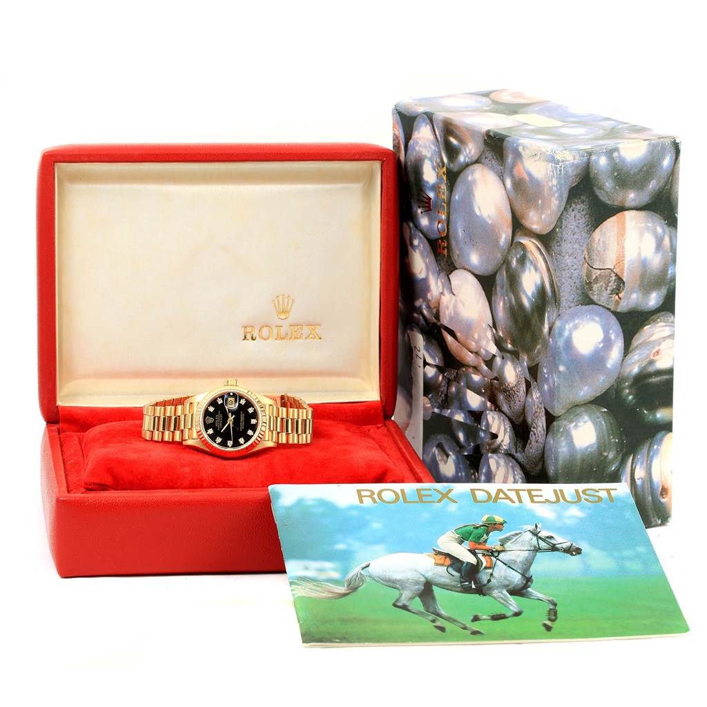 The image shows a Rolex President 69178 Women's Yellow Gold Black Dial 69178 Women's Yellow Gold Black Dial model watch in a red box with a booklet and an outer gift box.