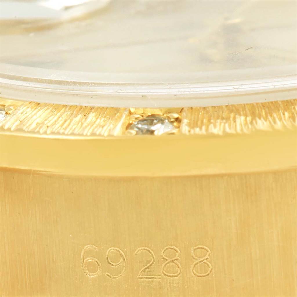 This close-up image shows the case edge, bezel with diamonds, and part number of a Rolex President 69288 Women's Yellow Gold Silver Dial 69288 Women's Yellow Gold Silver Dial model watch.