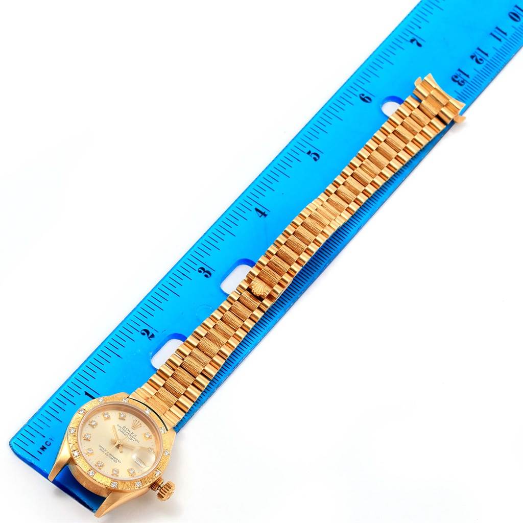 The image shows a Rolex President 69288 Women's Yellow Gold Silver Dial 69288 Women's Yellow Gold Silver Dial model watch placed next to a blue ruler, displaying the face and bracelet.