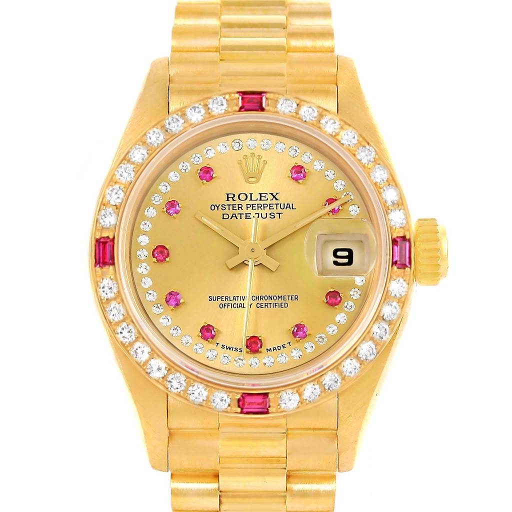 The image shows a front view of a Rolex President 69178 Women's Yellow Gold Champagne Dial 69178 Women's Yellow Gold Champagne Dial model watch, highlighting its gold case, diamond and ruby bezel, and date window.