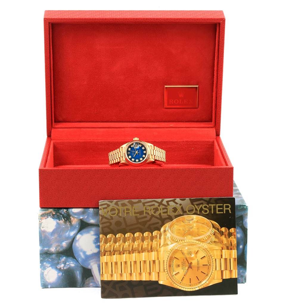 The Rolex President 69178 Women's Yellow Gold Blue Dial 69178 Women's Yellow Gold Blue Dial watch is shown in its open red box, accompanied by a promotional card.