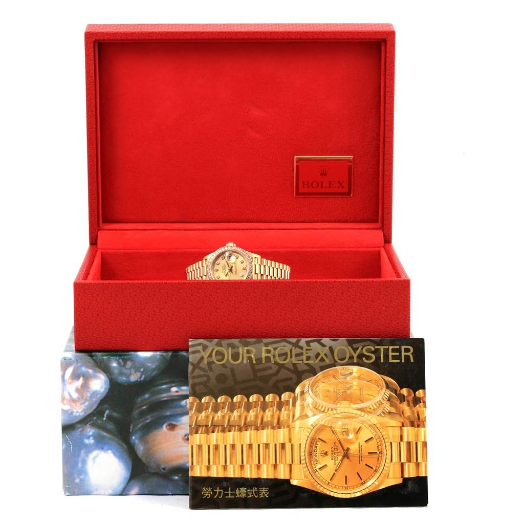 The Rolex President 69178 Women's Yellow Gold Champagne Dial 69178 Women's Yellow Gold Champagne Dial model watch is shown front-on in its opened red box with accompanying booklet in the foreground.