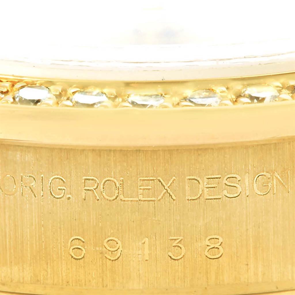 This image shows a close-up of the engraved bezel and casing of the Rolex President 69178 Women's Yellow Gold Champagne Dial 69178 Women's Yellow Gold Champagne Dial model watch.