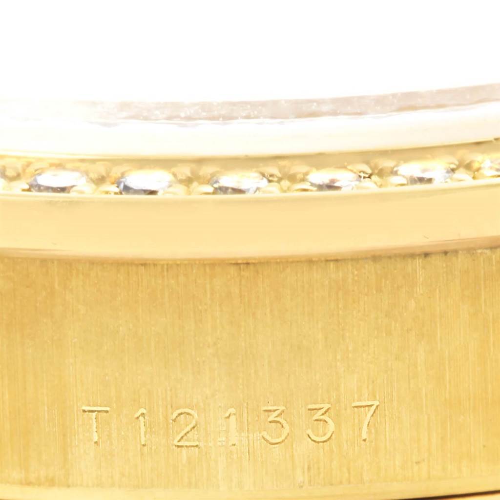 This image shows a close-up of a part of a Rolex President 69178 Women's Yellow Gold Champagne Dial 69178 Women's Yellow Gold Champagne Dial model, including the serial number and part of the bezel.