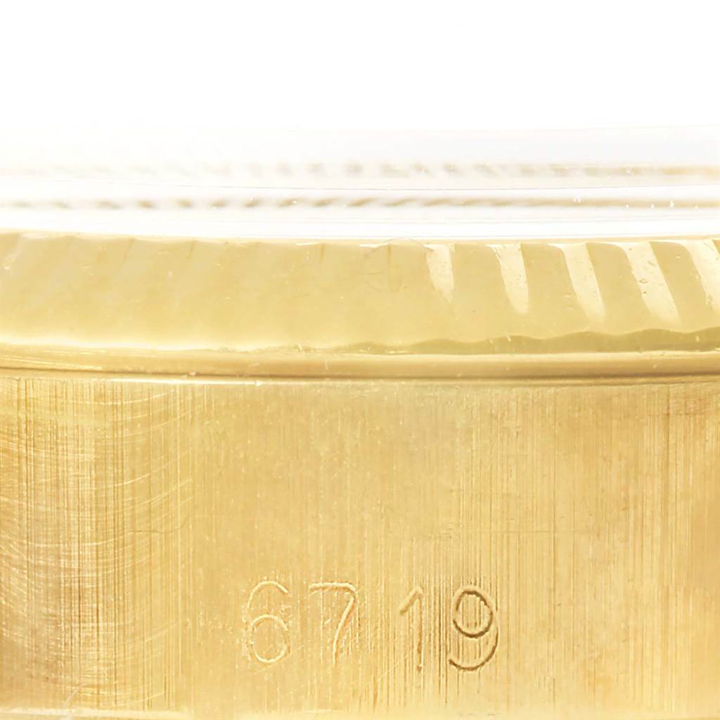 The image shows a close-up of the side of a Rolex President 6719 Women's Yellow Gold Silver Dial 6719 Women's Yellow Gold Silver Dial model watch, focusing on the engraved serial number.