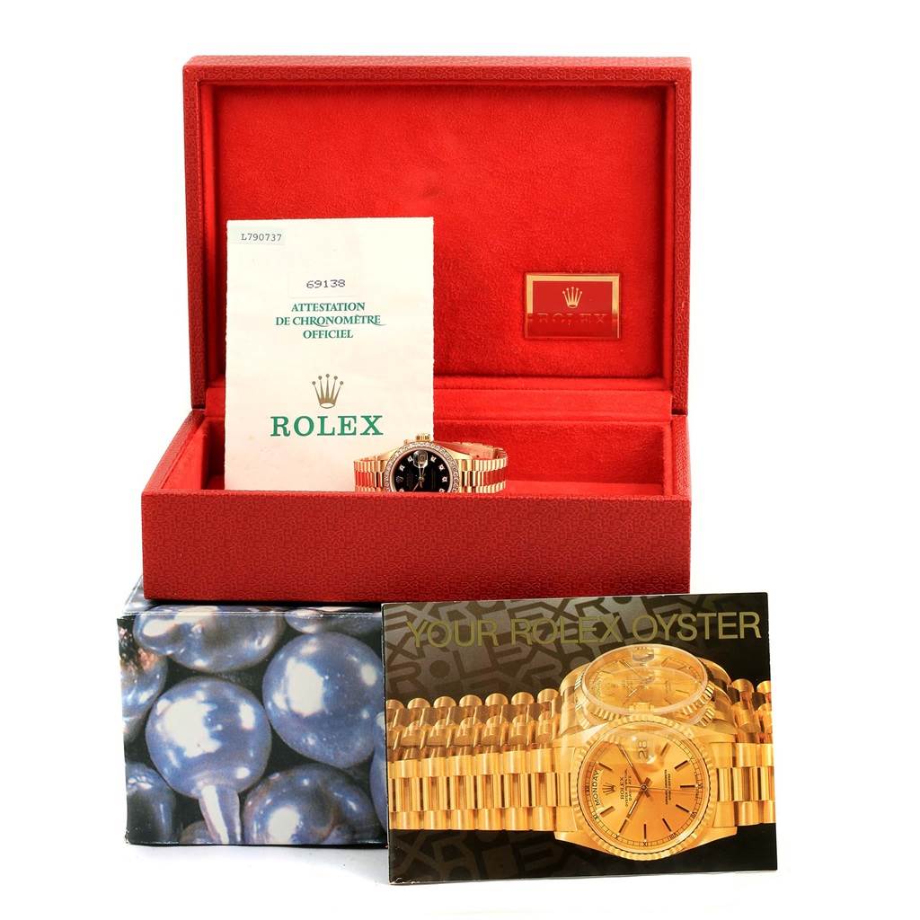 The image shows a Rolex President 69138 Women's Yellow Gold Black Dial 69138 Women's Yellow Gold Black Dial watch with its accessories, including the watch box, documentation, and brochure.