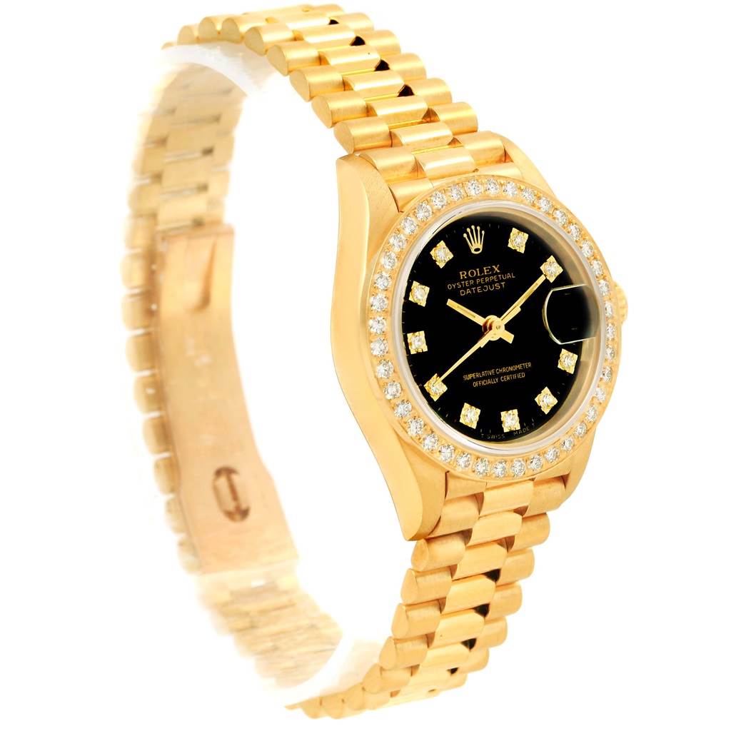 The image shows the front and side view of a Rolex President 69138 Women's Yellow Gold Black Dial 69138 Women's Yellow Gold Black Dial model watch with a gold bracelet and a diamond-encrusted bezel.