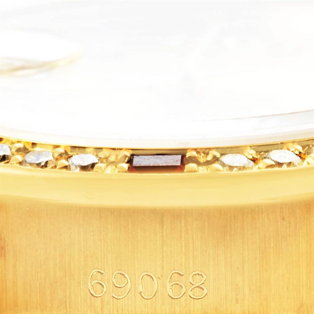 This image shows a close-up of the side of a Rolex President 69178 Women's Yellow Gold Champagne Dial 69178 Women's Yellow Gold Champagne Dial watch, highlighting the bezel with diamonds and the engraved model number, 69068, on the case.