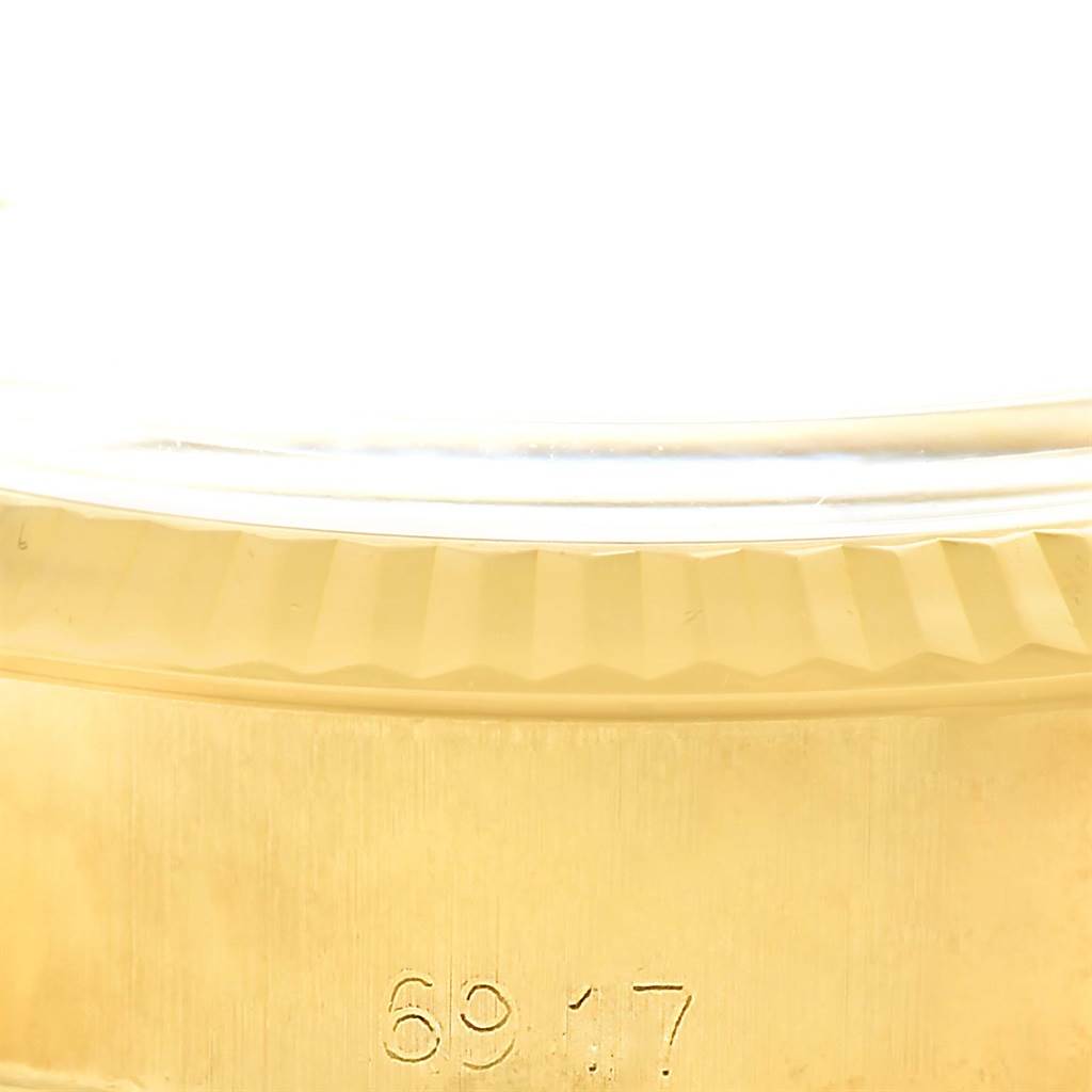 The image shows a close-up of the side and bezel of a Rolex President 6917 Women's Yellow Gold Champagne Dial 6917 Women's Yellow Gold Champagne Dial model watch.