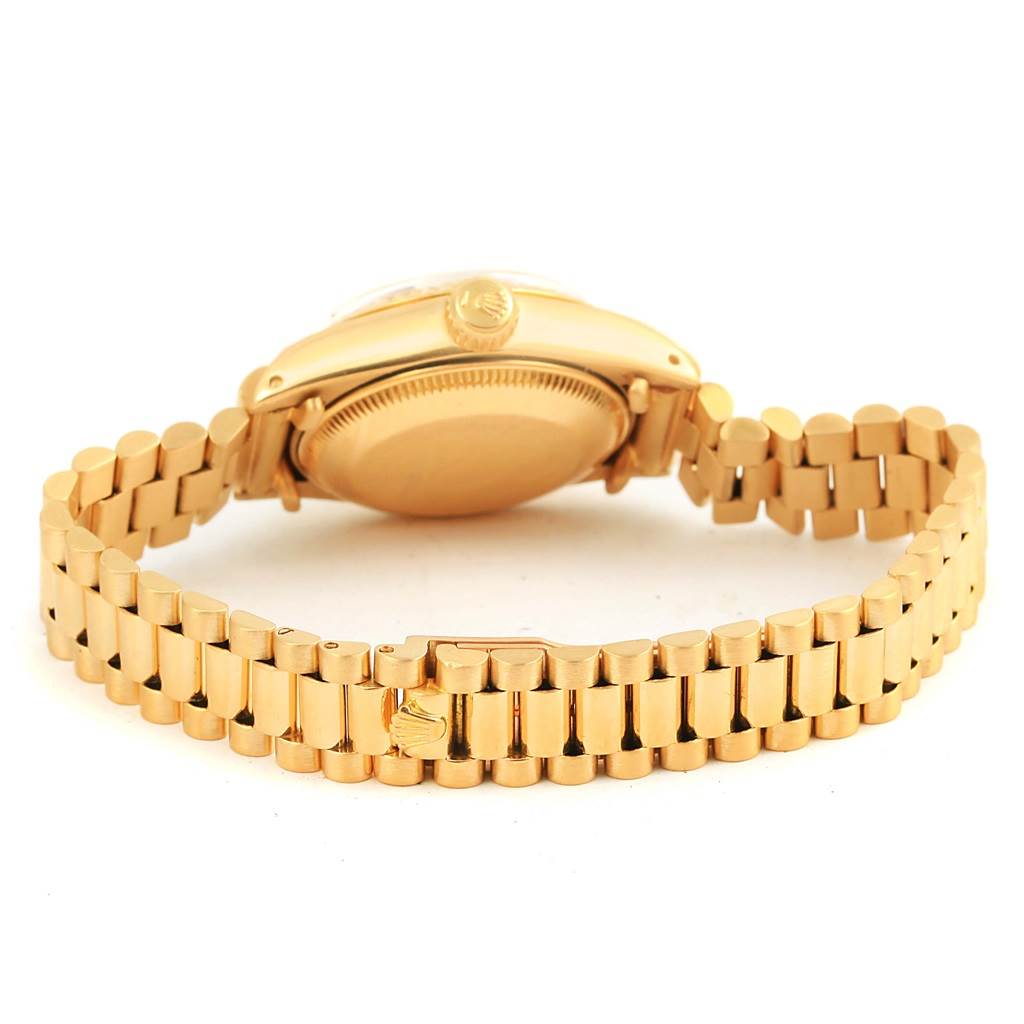 The image shows the back side of a gold Rolex President 6917 Women's Yellow Gold Champagne Dial 6917 Women's Yellow Gold Champagne Dial model watch with its bracelet fully extended.