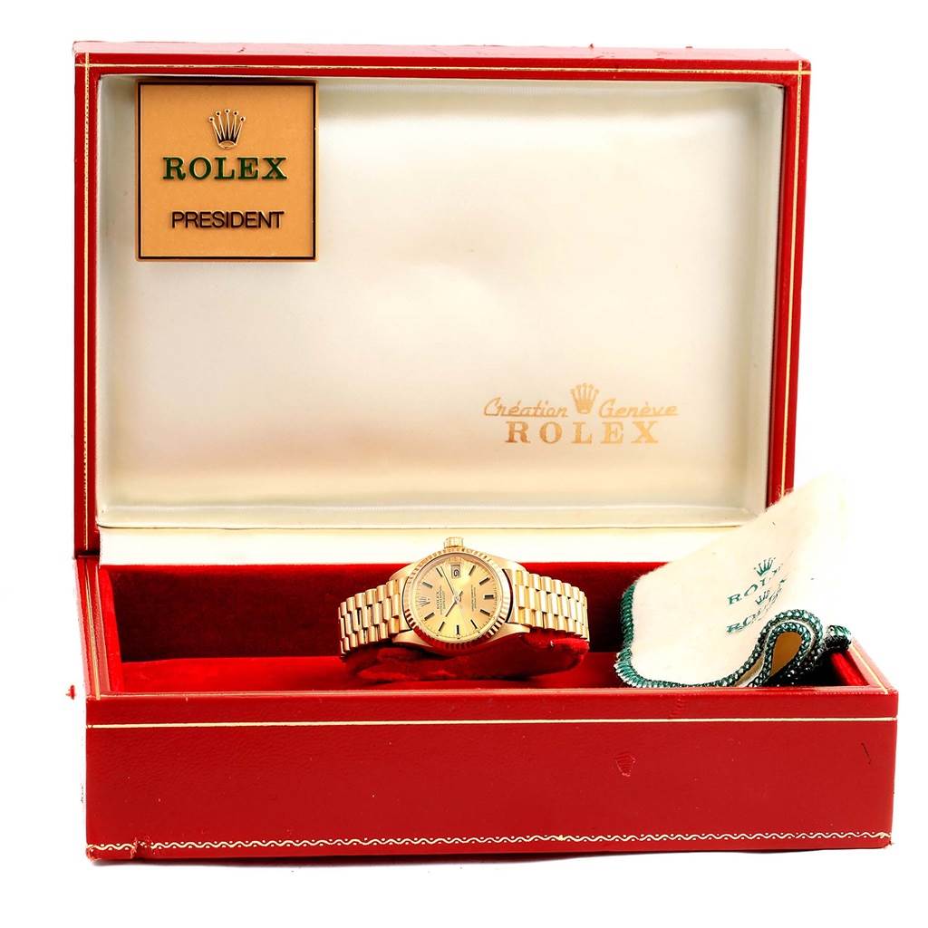 The image shows a Rolex President 6917 Women's Yellow Gold Champagne Dial 6917 Women's Yellow Gold Champagne Dial model watch in its box with a cleaning cloth beside it.