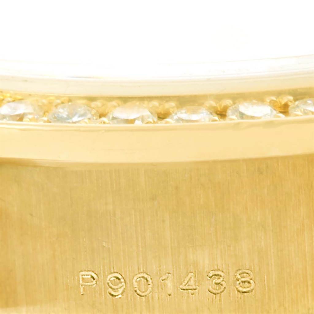 This close-up image of a Rolex President 79158 Women's Yellow Gold Mother of Pearl Dial 79158 Women's Yellow Gold Mother of Pearl Dial watch features the bezel with diamond accents and part of the engraved serial number.