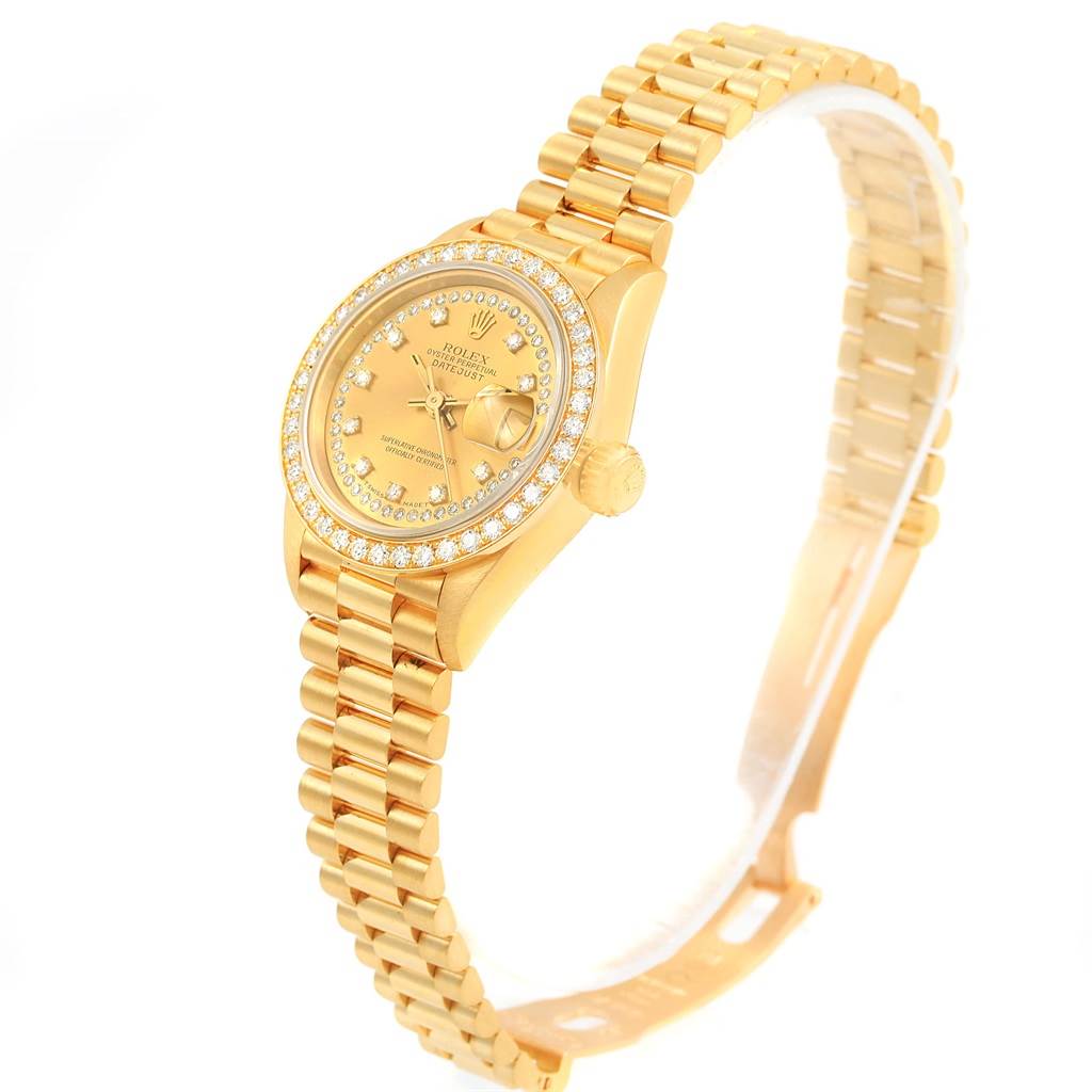 The Rolex President 69138 Women's Yellow Gold Champagne Dial 69138 Women's Yellow Gold Champagne Dial watch is shown at an angled view, highlighting the gold case, diamond bezel, dial, and bracelet.