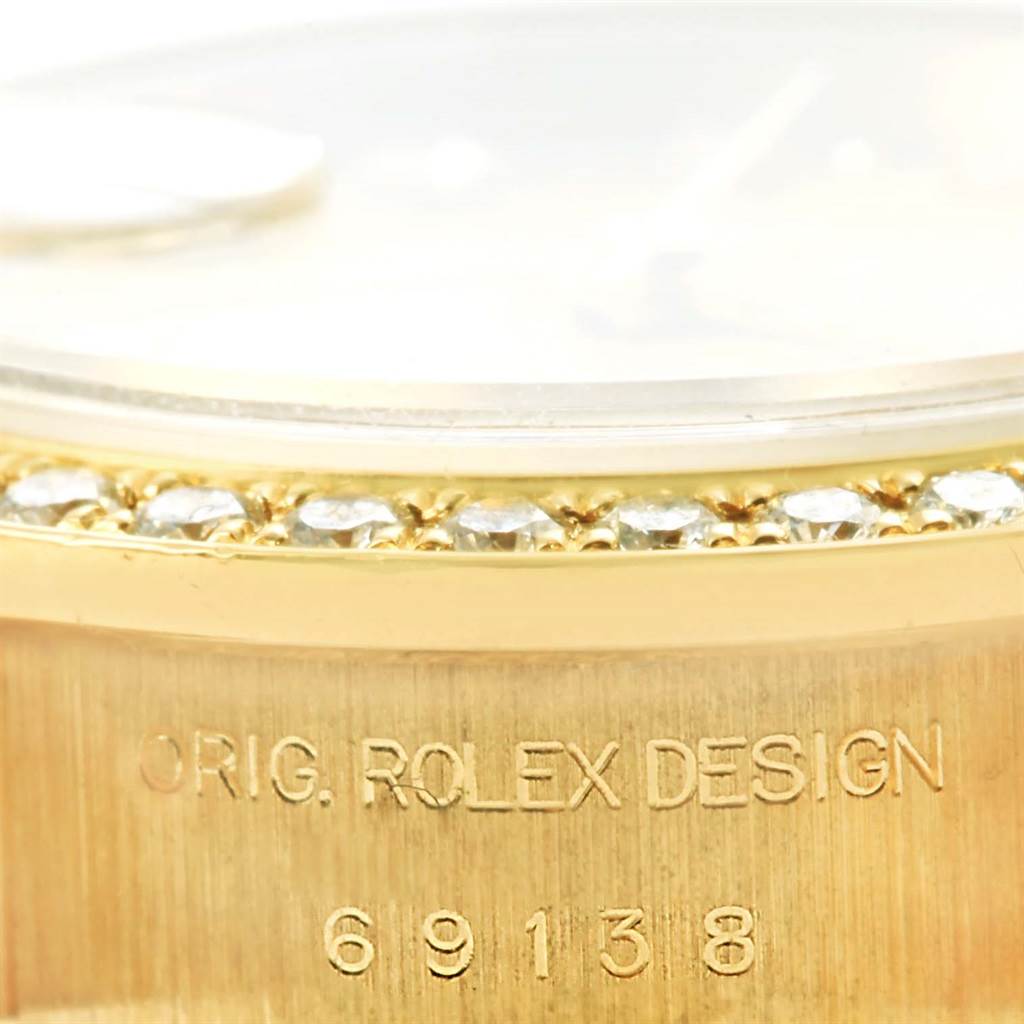The image shows a close-up of the bezel with diamonds and case edge of a Rolex President 69138 Women's Yellow Gold Champagne Dial 69138 Women's Yellow Gold Champagne Dial model, including the engraved model number 69138.