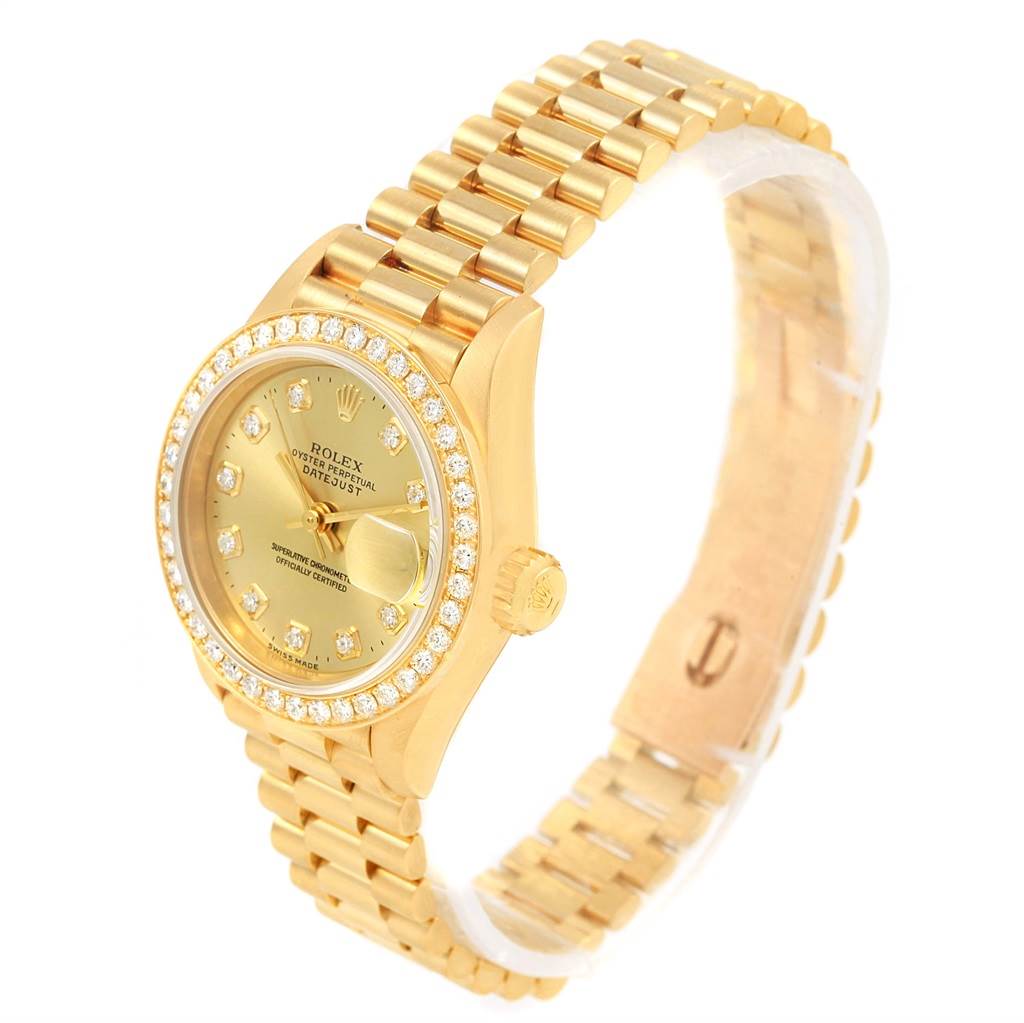 The Rolex President 69178 Women's Yellow Gold Champagne Dial 69178 Women's Yellow Gold Champagne Dial model watch is shown at an angle displaying its gold case, diamond bezel, bracelet, dial, and date window.