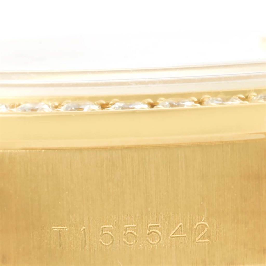 This close-up image of a Rolex President 69178 Women's Yellow Gold Champagne Dial 69178 Women's Yellow Gold Champagne Dial model watch shows the edge of the bezel and part of the case with a serial number.