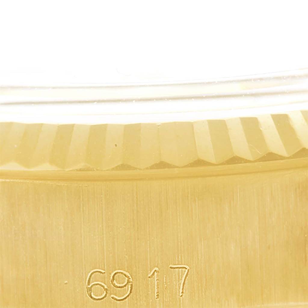This close-up image shows the fluted bezel and part of the case of a President model by Rolex.