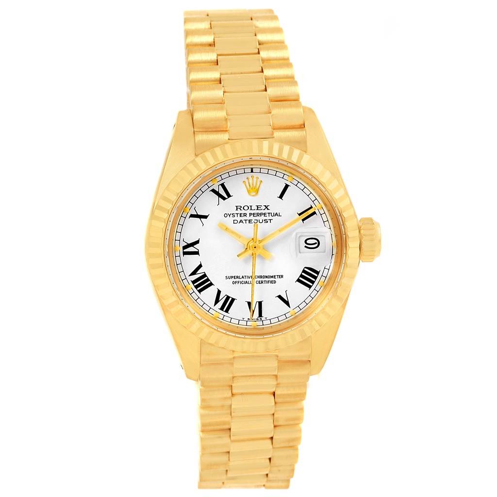 The image shows a frontal view of a Rolex President 6917 Women's Yellow Gold White Dial 6917 Women's Yellow Gold White Dial model watch with a gold bracelet, white dial, and Roman numeral hour markers.