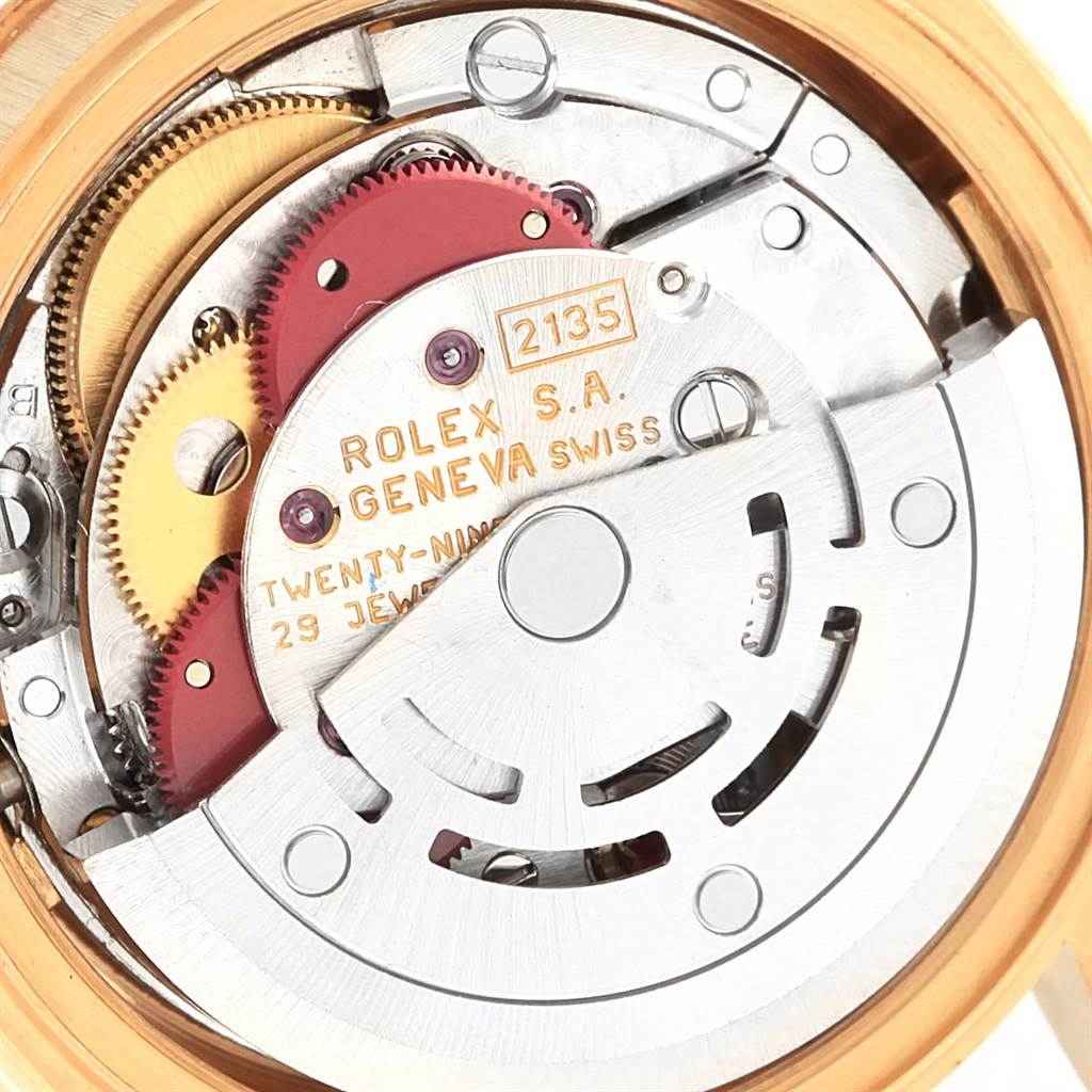 The image shows the intricate inner mechanics and components of the Rolex President 69178 Women's Yellow Gold White Dial 69178 Women's Yellow Gold White Dial model watch movement, focusing on gears and inscriptions.