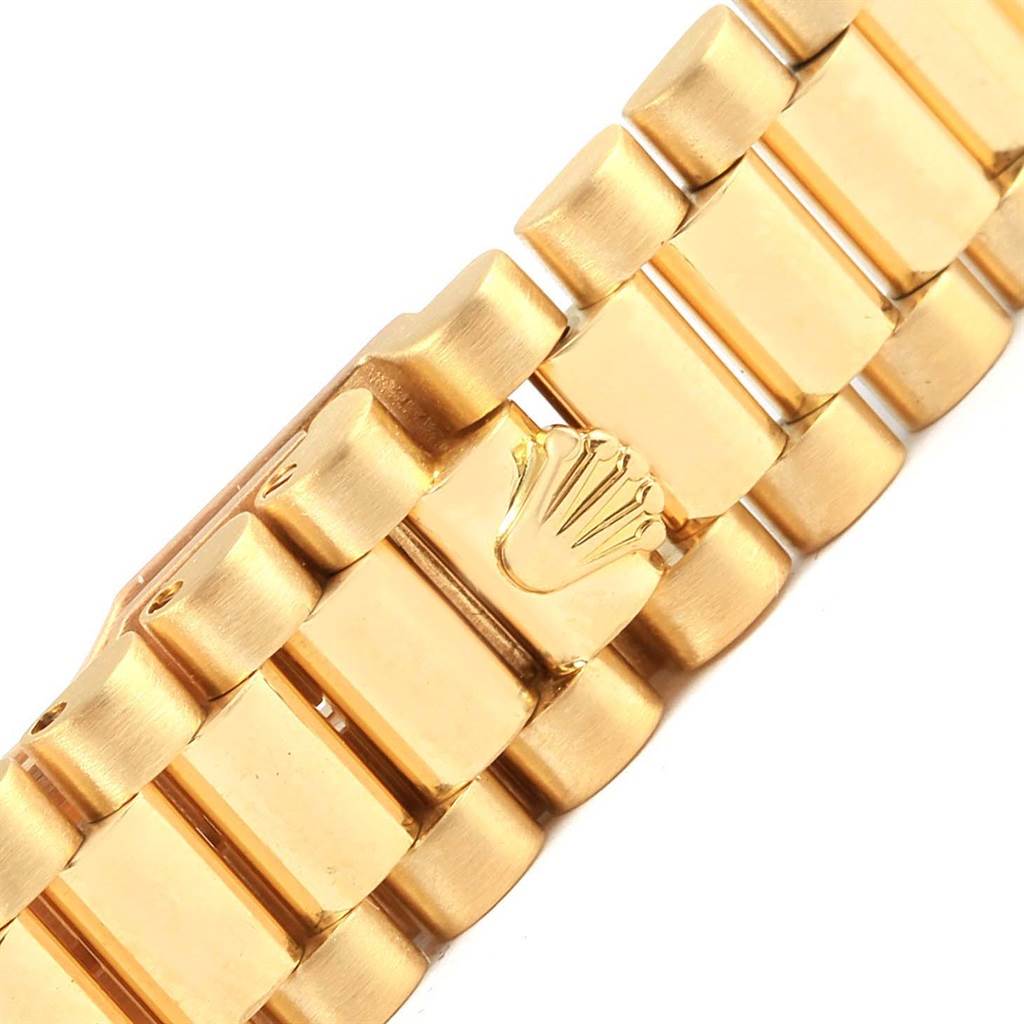 This close-up image showcases the gold bracelet of a Rolex President 69138 Women's Yellow Gold White Dial 69138 Women's Yellow Gold White Dial model watch, highlighting the Rolex logo on the clasp.