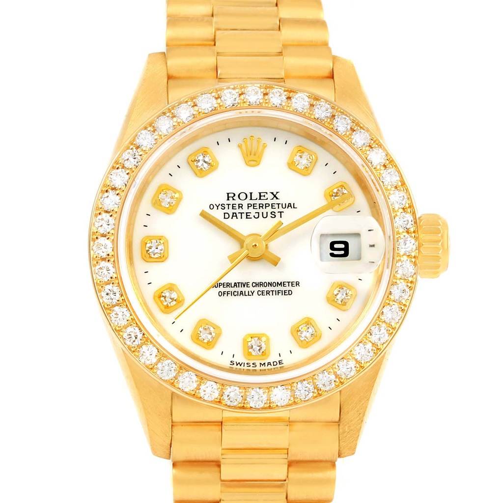 The image shows a front view of a Rolex President 69138 Women's Yellow Gold White Dial 69138 Women's Yellow Gold White Dial model with a gold band, diamond bezel, and white dial displaying the date.