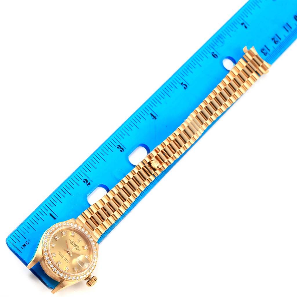 The image shows a Rolex President 69178 Women's Yellow Gold Champagne Dial 69178 Women's Yellow Gold Champagne Dial watch laid flat next to a blue ruler, displaying the watch face and gold bracelet.