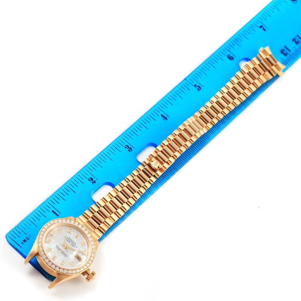 The image shows a Rolex President 79138 Women's Yellow Gold Mother of Pearl Dial 79138 Women's Yellow Gold Mother of Pearl Dial model watch with its face and part of the bracelet displayed, measured by a blue ruler.