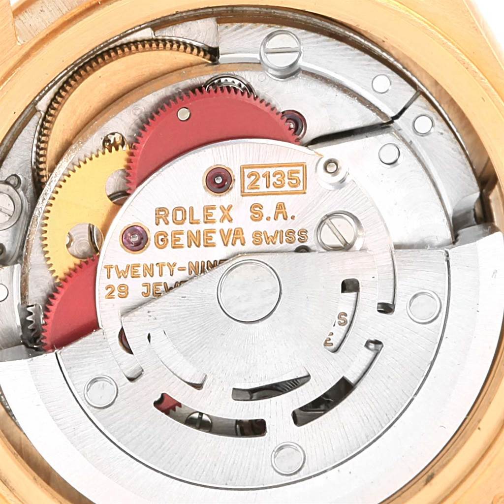This close-up image shows the intricate internal mechanism of the Rolex President 69178 Women's Yellow Gold Blue Dial 69178 Women's Yellow Gold Blue Dial model watch, highlighting its gears and inscriptions.
