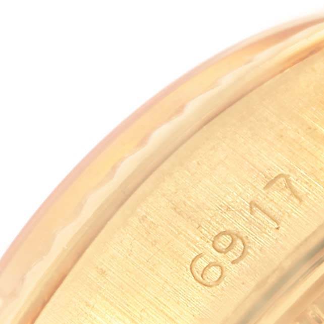 This close-up angle shows a part of the case and bezel of a Rolex President 6917 Women's Yellow Gold Champagne Dial 6917 Women's Yellow Gold Champagne Dial model with visible engravings.