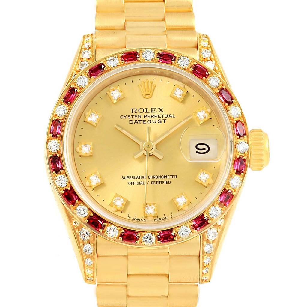 The image shows a frontal view of the Rolex President 69198 Women's Yellow Gold Champagne Dial 69198 Women's Yellow Gold Champagne Dial model watch, highlighting its gold bracelet, diamond and ruby bezel, and date feature.