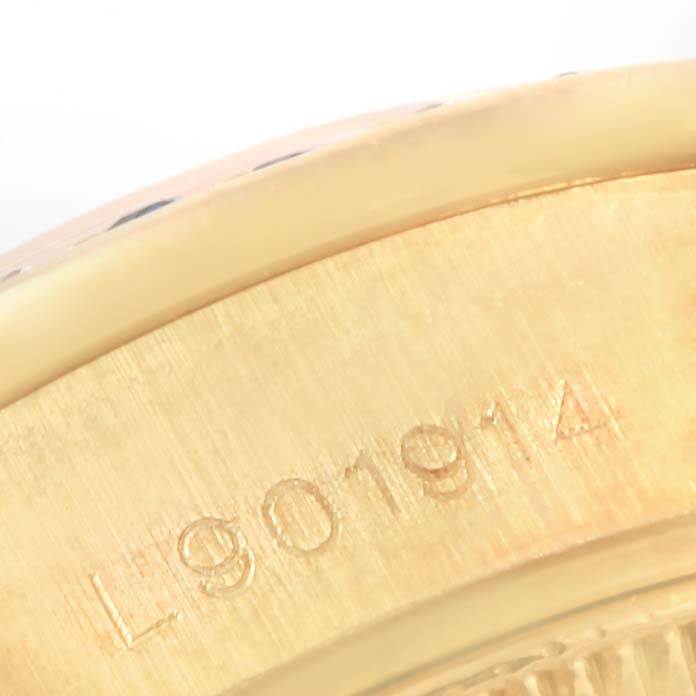The image shows a close-up of the side of a Rolex President 69038 Women's Yellow Gold Blue Dial 69038 Women's Yellow Gold Blue Dial model, focusing on the serial number engraved on the gold case.