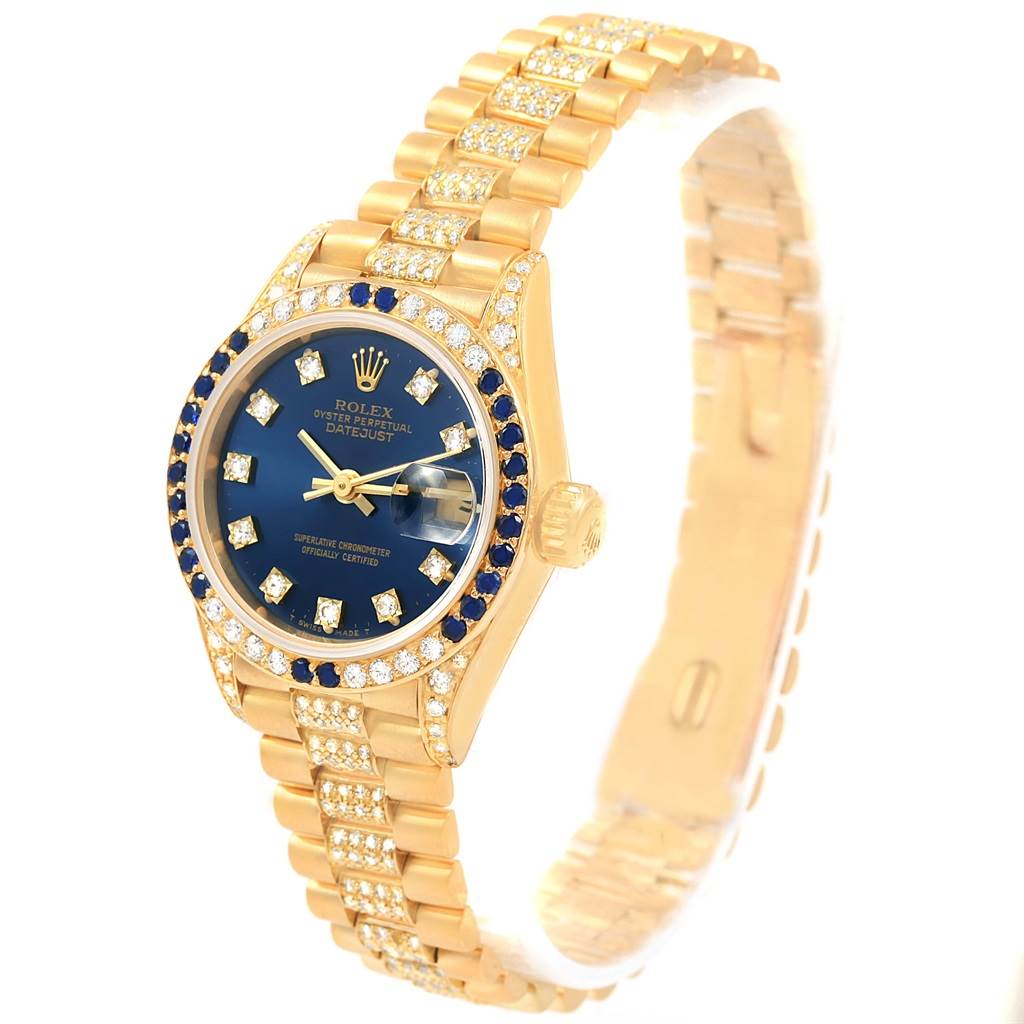 The image shows a Rolex President 69038 Women's Yellow Gold Blue Dial 69038 Women's Yellow Gold Blue Dial model watch from an angled view, highlighting the dial, bezel, crown, and bracelet with diamonds.