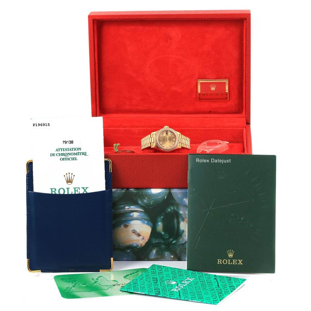 The image shows a Rolex President 79138 Women's Yellow Gold Champagne Dial 79138 Women's Yellow Gold Champagne Dial model watch in its box along with certificates, manuals, and additional accessories.