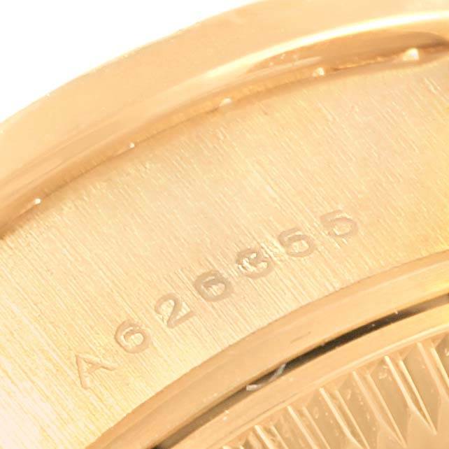 This close-up image shows the serial number of the President model by Rolex engraved on its gold casing.