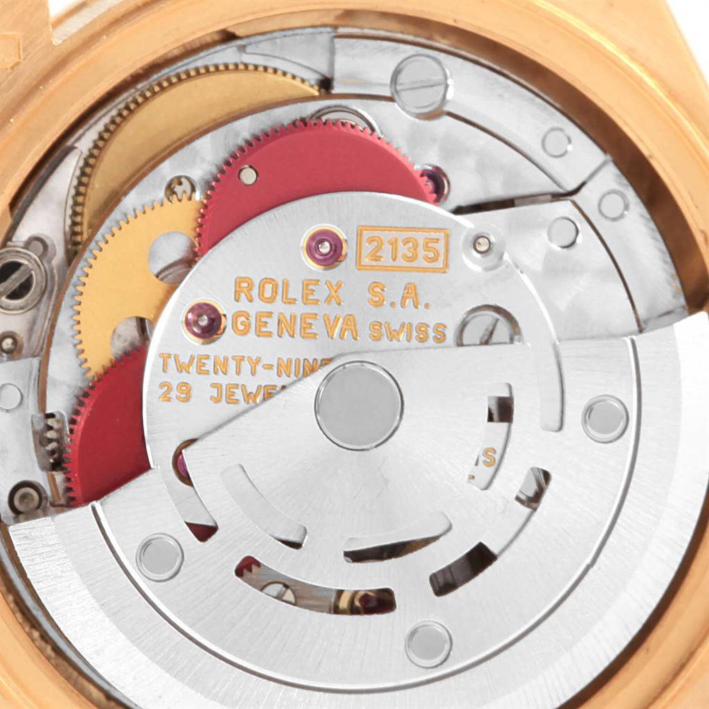 The image shows the movement mechanism of the Rolex President 69178 Women's Yellow Gold White Dial 69178 Women's Yellow Gold White Dial watch model, highlighting the intricate gears and rotor.