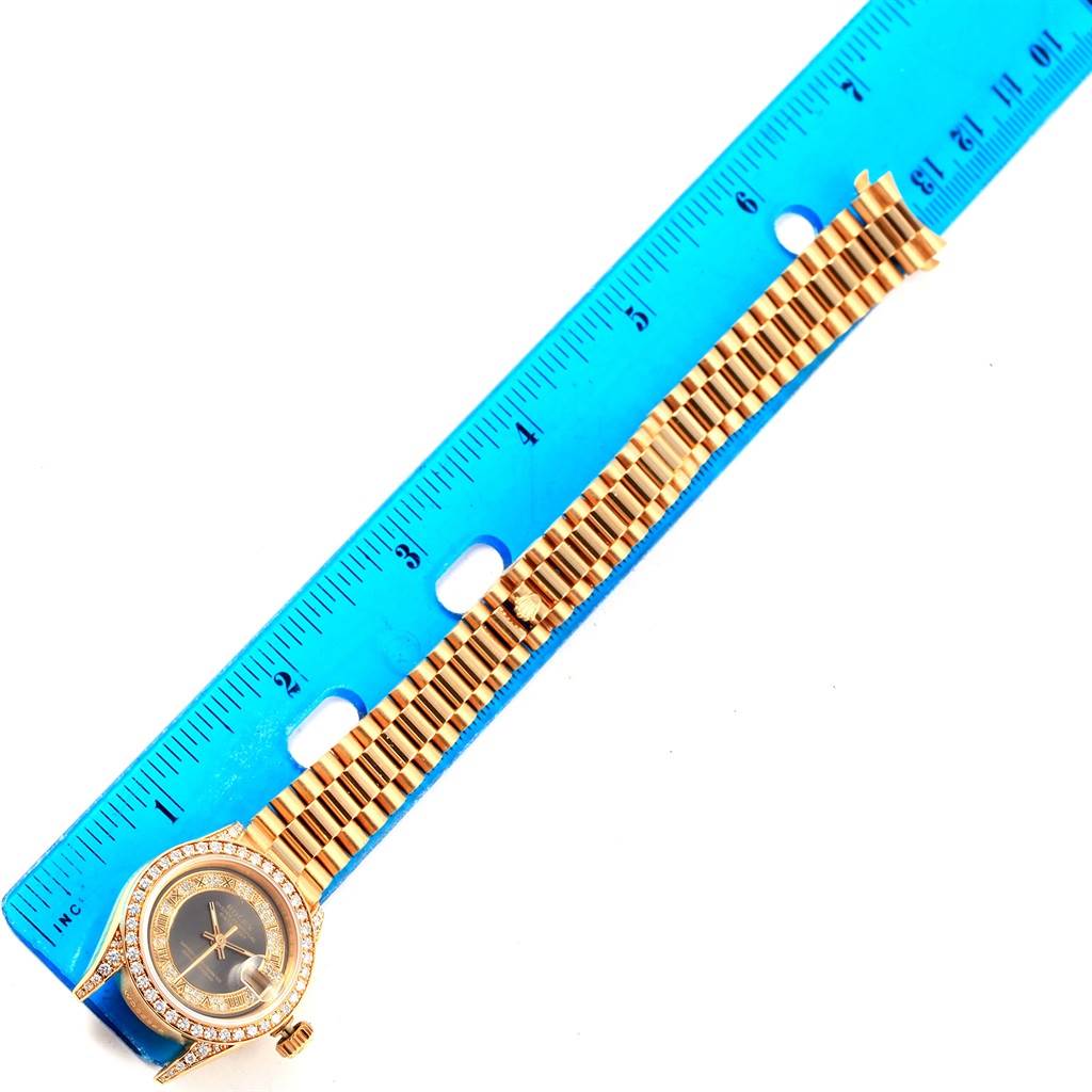 The image shows a Rolex President 69158 Women's Yellow Gold Grey Dial 69158 Women's Yellow Gold Grey Dial watch with the face, bezel, and full bracelet laid next to a blue ruler for scale.