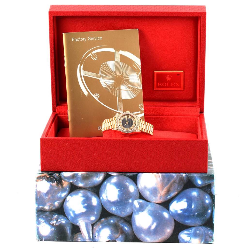 The image shows a Rolex President 69158 Women's Yellow Gold Grey Dial 69158 Women's Yellow Gold Grey Dial model watch in a red box with a booklet and a tag.